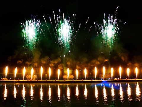 Fireworks over the lagoon during the Carnival celebration in Venice, Italy. Reflection in water. Blurry lights.