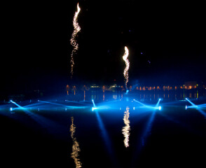 Fireworks over the lagoon during the Carnival celebration in Venice, Italy. Reflection in water. Blurry lights.