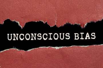 Unconscious bias message written on ripped torn red paper on black background. Conceptual...