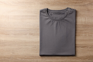 One blank t-shirt on wooden background, top view. Mockup for design