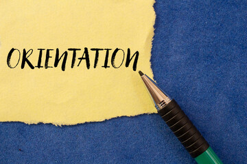 Orientation message written on ripped torn yellow paper on blue background. Conceptual orientation symbol. Copy space.