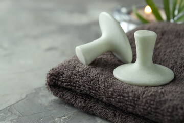 Spa stones and towel on grey table, closeup