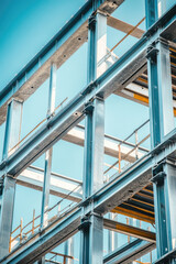 Steel frame structure of modern building construction against blue sky
