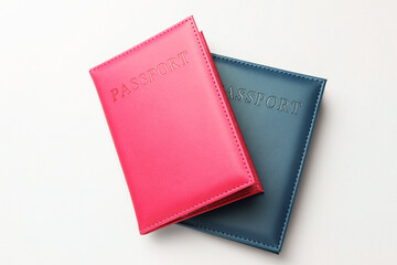 Passports in color covers on light background, top view