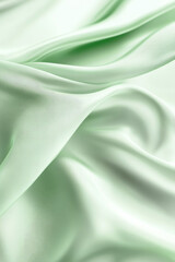 Soft mint green silk fabric with flowing folds and smooth texture for fashion design