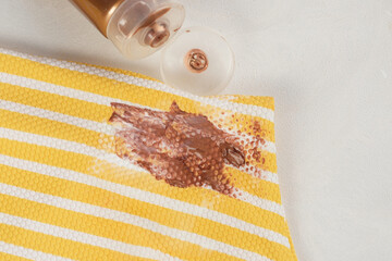 Dirty cosmetic stain self tanner in a swimsuit yellow striped. top view. The concept of cleaning stains on clothes