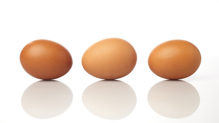 Isolated in White Background Three Brown Eggs Arranged in a Straight Line on a Reflective Surface