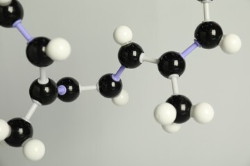 Molecule of retinol (vitamin A) on light grey background, closeup. Chemical model