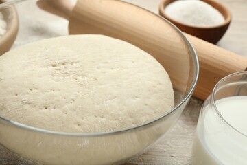 Rolling pin and different ingredients on light wooden table, closeup
