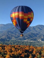 Fototapeta premium Soaring high above vibrant autumn foliage with majestic mountains in the background