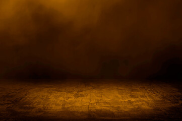 concrete floor with dark gold background and yellow smoke float above. abstract image featuring a textured concrete floor in a dimly lit space filled with fog or mist. dark room with orange light.