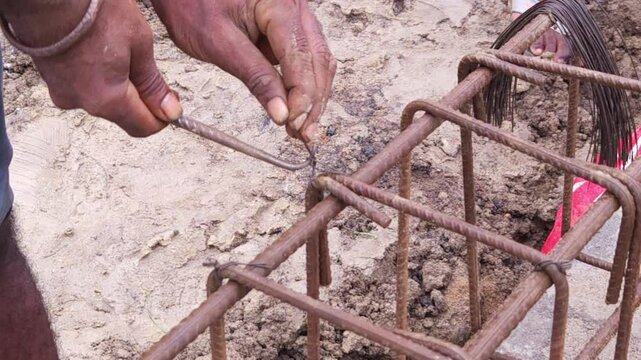 Construction workers using reinforced tmt steel bar with ease at the construction site, Reinforced bar (rebar). TMT steel rods tied together forming the core of concrete