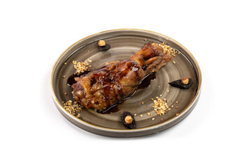 Stinco di maiale brasato con prugne e nocciole