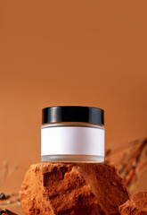 A jar of cosmetic moisturizer cream isolated on a rock with clear background