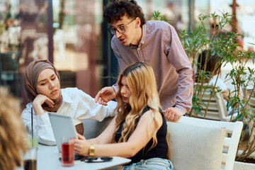 A Diverse MultiEthnic Group Reviewing Projects During a Work Break in a Caffee.