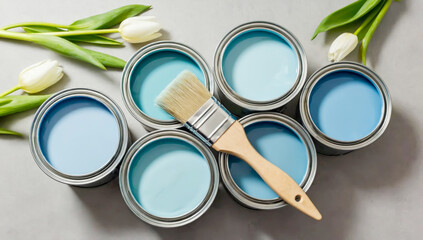 Open paint cans in spring palette with pastel blue shades with brush and white tulips. Perfect concept for home renovation, repair, interior design, color trends, and creative DIY painting projects