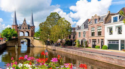 The famous Waterpoort gate in Sneek on a sunny day with flowers in bloom, Friesland, Netherlands
