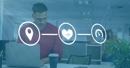 Image of media icons over biracial casual businessman using laptop in office