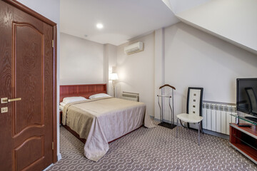 double bed with pillows in interior with night lamp in hotel room
