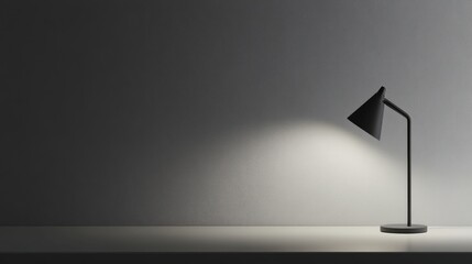 A sleek black desk lamp casting light on a minimalist grey surface, perfect for modern workspace or interior design concepts.