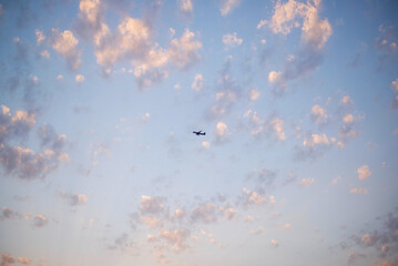 Airliner with contrails flying in a blue sky with beautiful cumulus clouds or cumulonimbus. Photography, Full frame. High quality photo