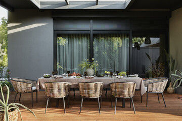 Aesthetic composition of terrace interior with table, chair, garden furnitures, vase with flowers, big window, fruits, food, tableware, plants and personal accessories. Home decor. Template.