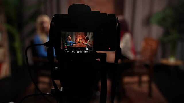 Two Influencers of women being interviewed in a loft-style podcast studio