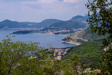 overlooking the town of Budva and the boat in sea with mountains and green forest in the background. High quality photo