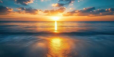 Obraz premium Golden sunset hues kiss the deep blue-green surface, mirroring warmth in tranquil ripples under an amber sky