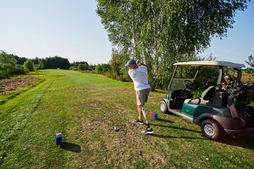 A golfer with a prosthetic leg prepares to drive the ball down a lush fairway under a clear blue...