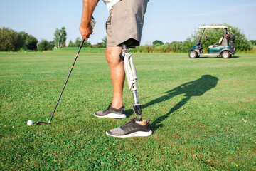 A determined golfer stands poised to hit the ball, showcasing their prosthetic leg while enjoying a...