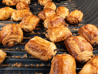 Pain au chocolat: French chocolate bread on shelf from bakery. Freshly Baked Golden French Croissants