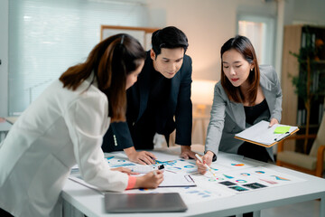 Corporate team collaborating, examining financial charts, strategizing business development