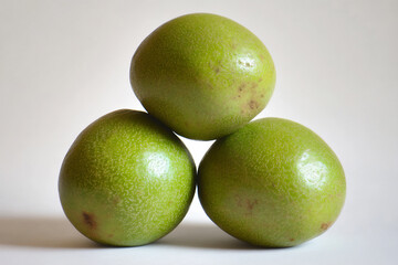 a photograph of three fresh, green jujube fruits,