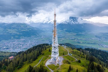 A wind turbine in a scenic countryside setting, with rolling hills and the sun setting in the background