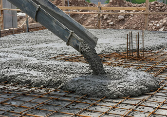 Cement being poured over a metal reinforcement structure at a worksite