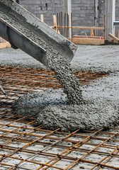  Building foundation construction with freshly poured concrete over steel grid.