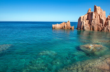 formation of red granite rocky peak on  clear sea in Sardinia Italy - Rocce Rosse Arbatax.