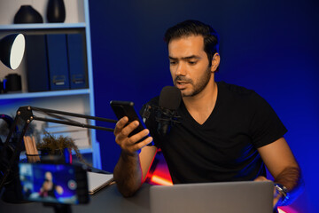 Broadcaster talking to listener on live streaming online with blurred screen, reading comment on...