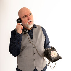 Acteur homme mature avec un vieux téléphone dans les main et faisant des expressions...