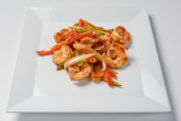 Traditional Thai prawns with carrot pepper and lemon grass served on a plate with a white background
