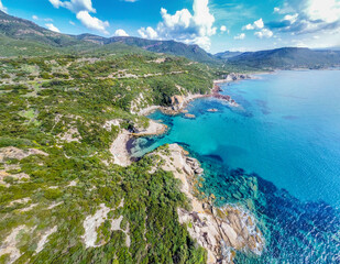 Aerial view of Cala Cumpoltitu shoreline under a cloudy sky