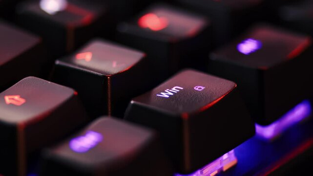 Human finger is clicking on the WIndows button on the computer keyboard, close up view. The finger presses Windows on the keyboard key, macro shot. Loop footage.