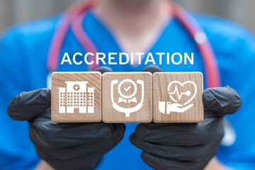 Doctor holding wooden blocks with icons sees word: ACCREDITATION. Warranty, standards, ISO quality...