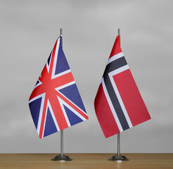 Table flags United Kingdom and Norway on grey blurred background