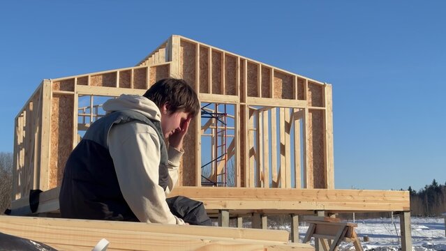 Sad angry woman having problems with construction of her wooden house
