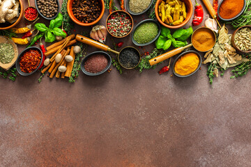 A vibrant collection of fresh, fragrant spices and herbs arranged in a colorful display on a rich...