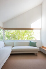 Modern interior design in a bright living room with natural light and greenery outside