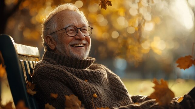 An elderly man sits on a park bench, chuckling joyfully while surrounded by vibrant autumn leaves. The warm sunlight enhances the beautiful fall atmosphere and his smile