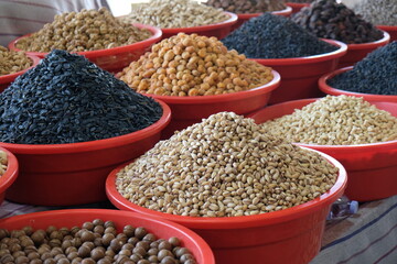 Obraz premium various nuts and dried fruits in red plastic containers at the market